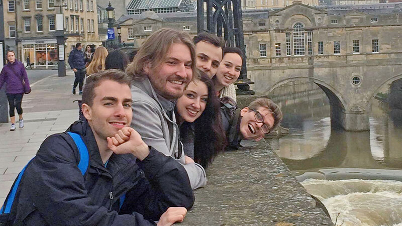 Students in a row leaning against wall