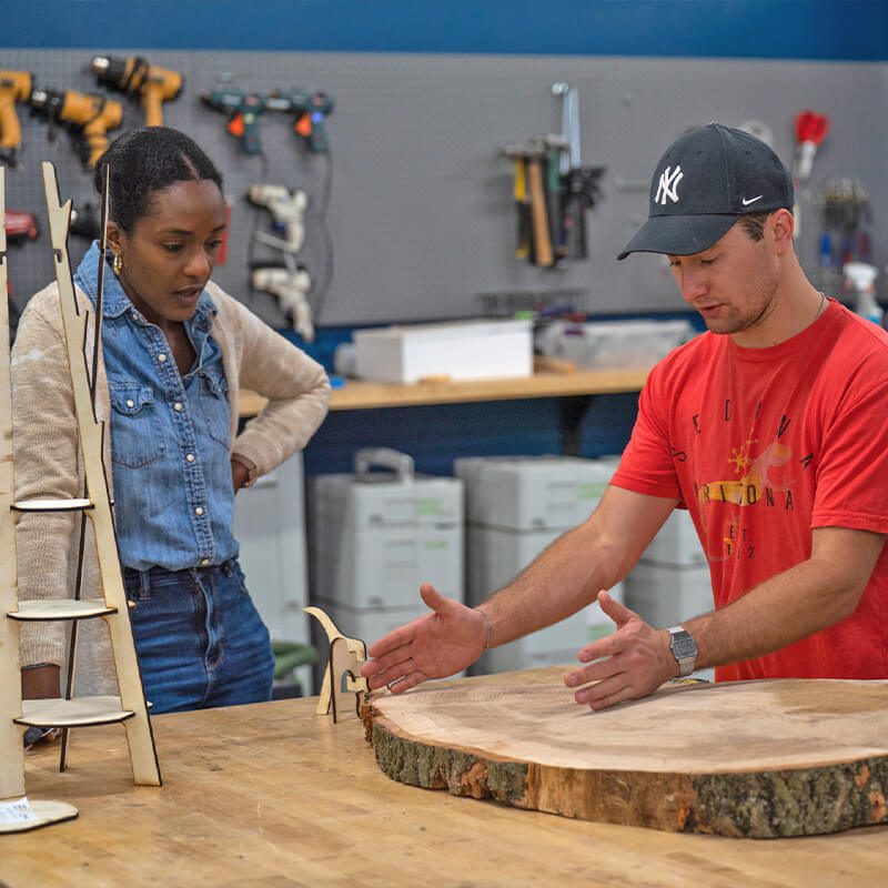 Student measuring piece of wood for project