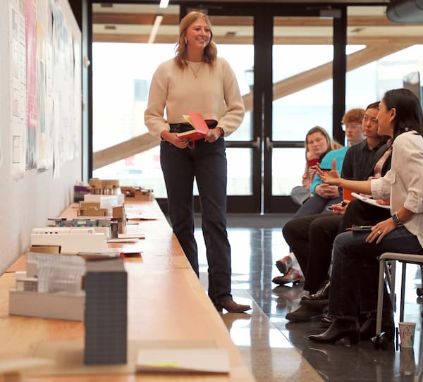 A professor stands in front of seated students.