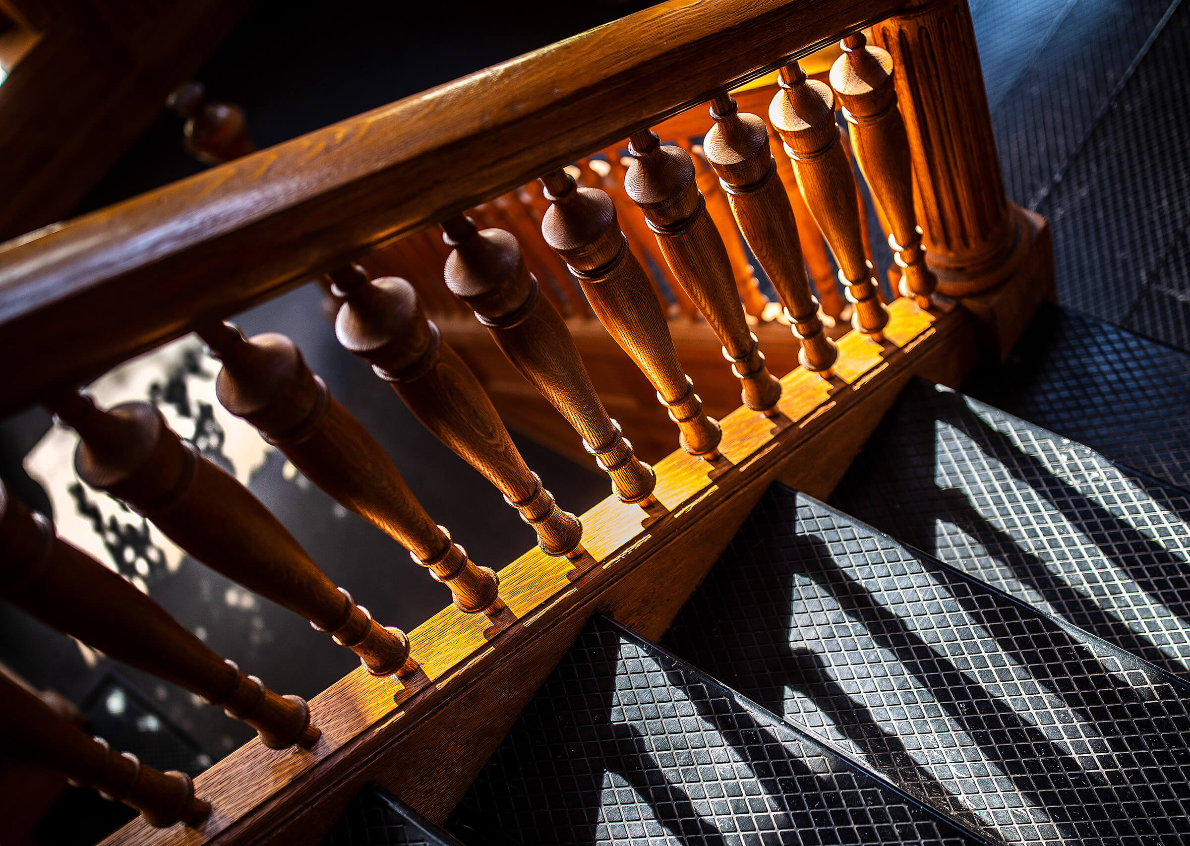 Light creating shadows through wooden railing of Architecture hall staircase