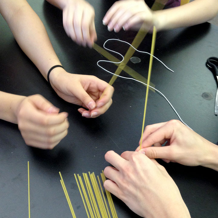 students building something out of string and uncooked noodles