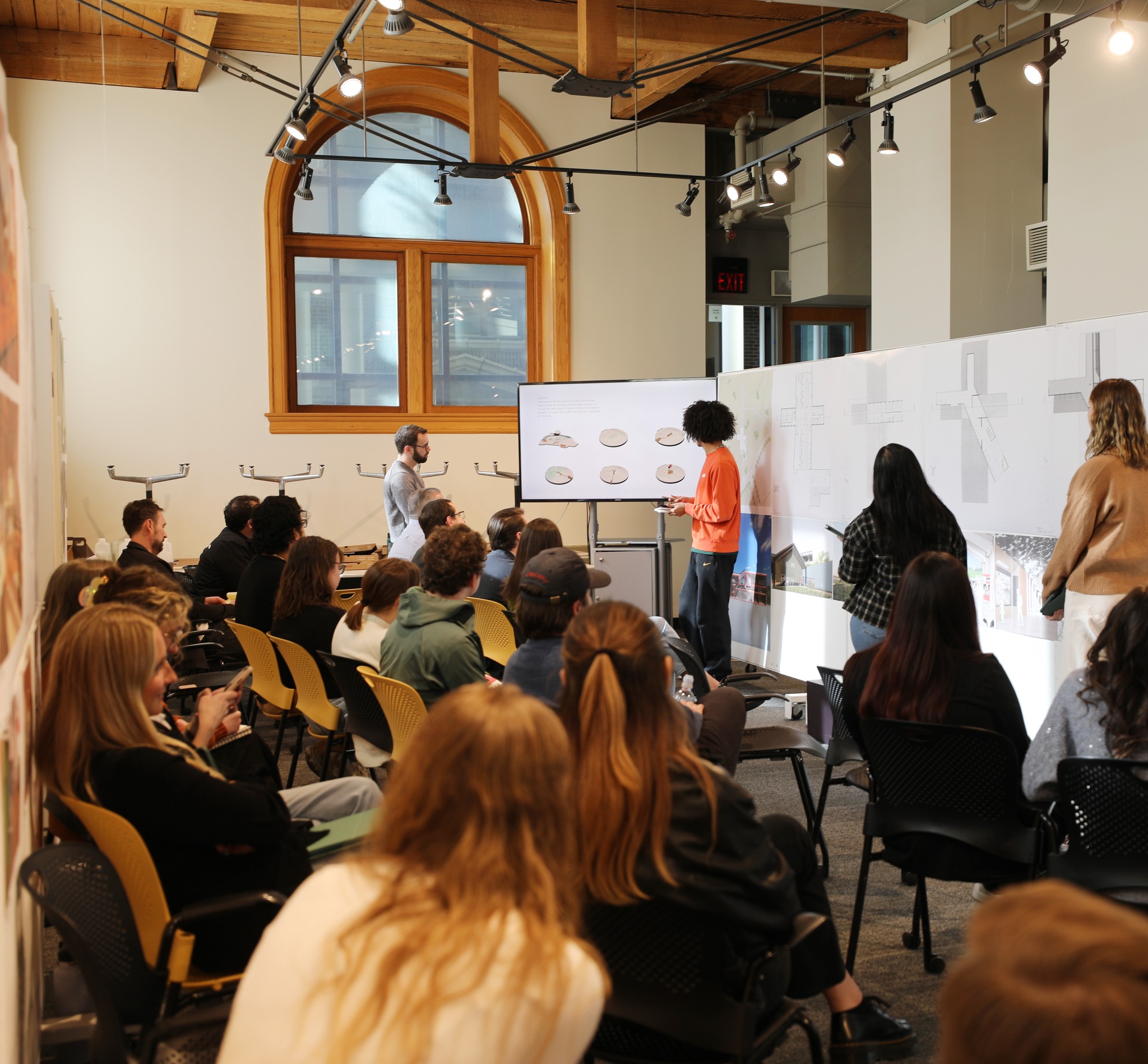 a student giving a presentation in front of a room full of peers