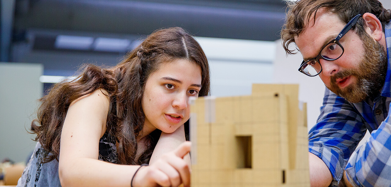 Student and faculty member looking at project