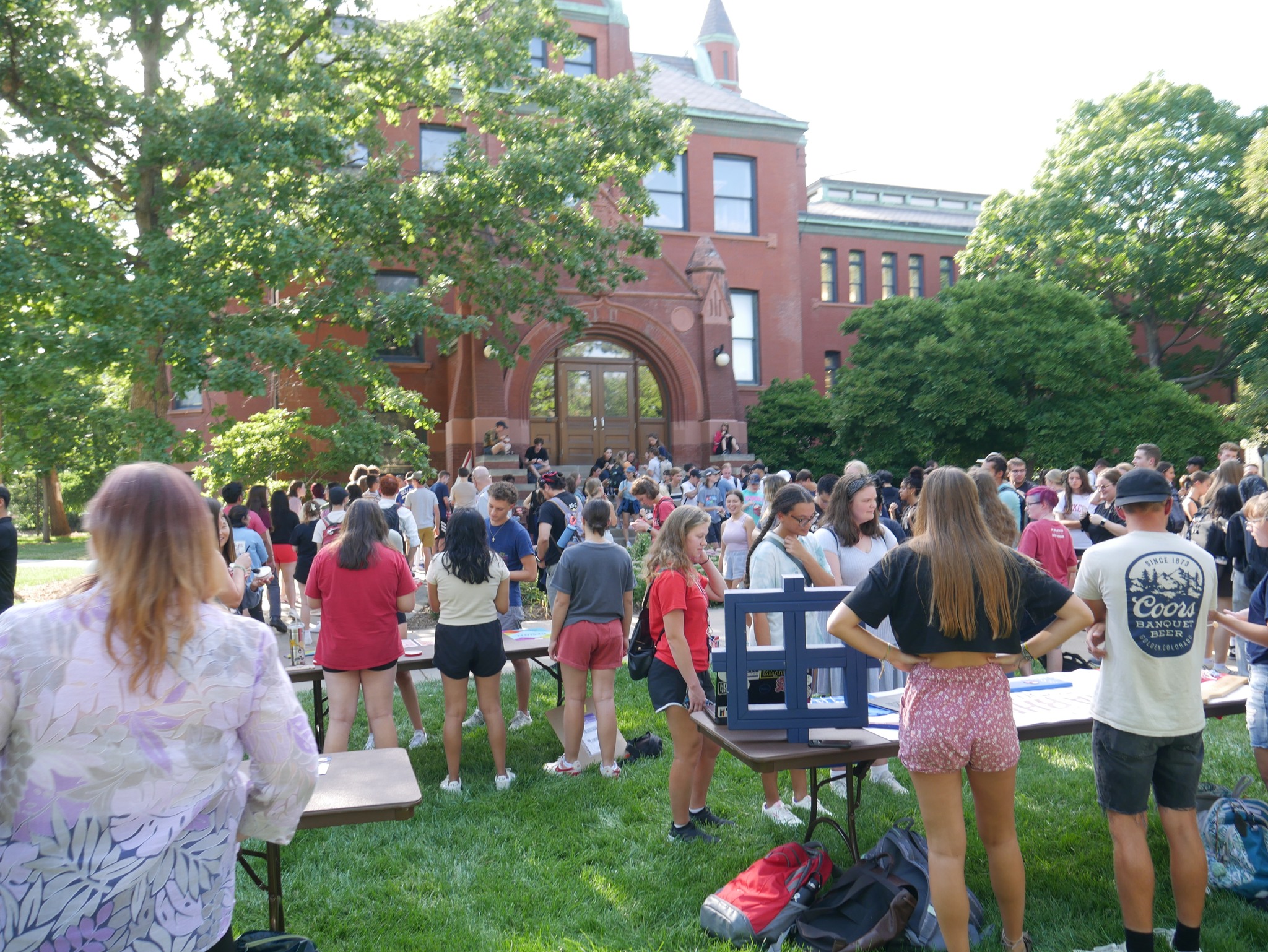 students looking at booths and talking in front of architecture hall