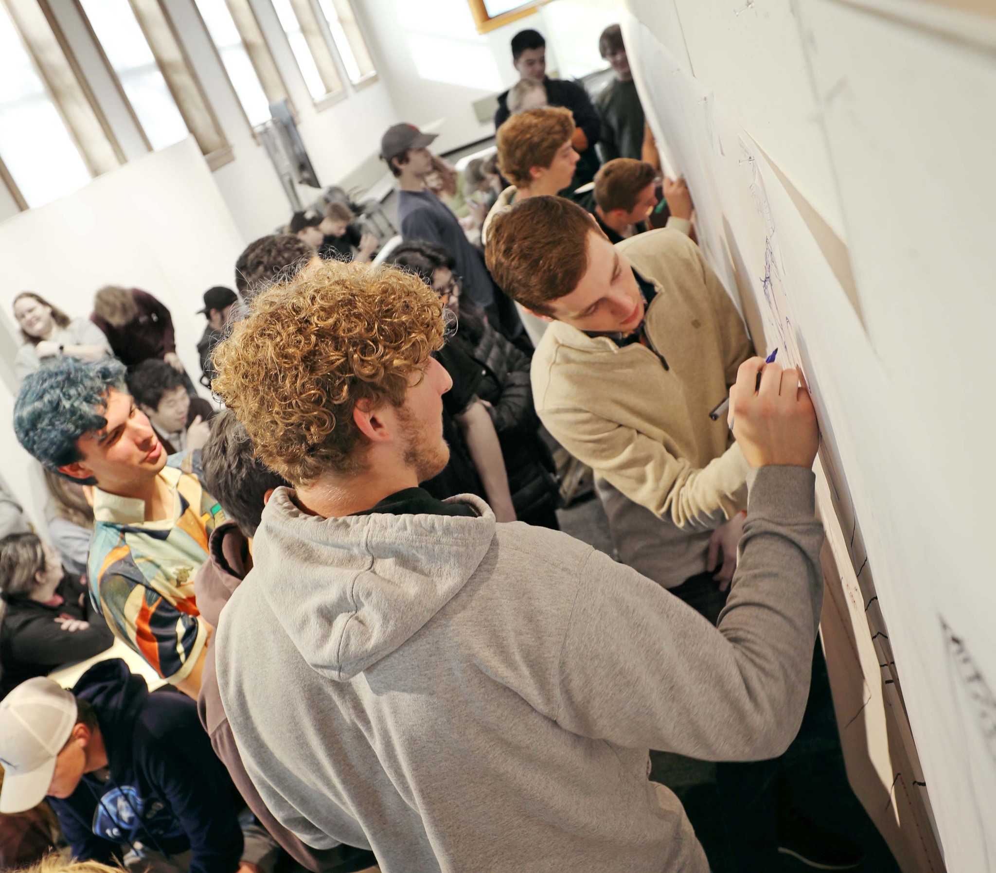 two students drawing on the whiteboard