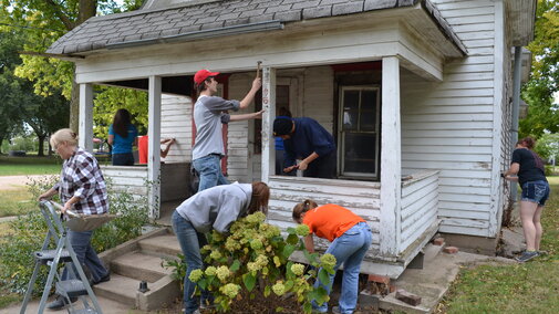 a group of students working together to build a house