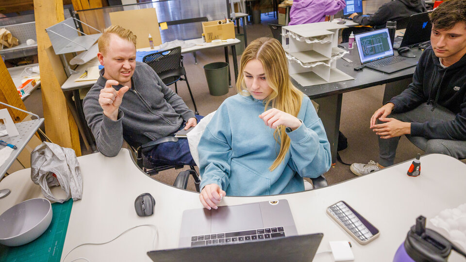 Faculty member looking at computer screen and reacting along with students