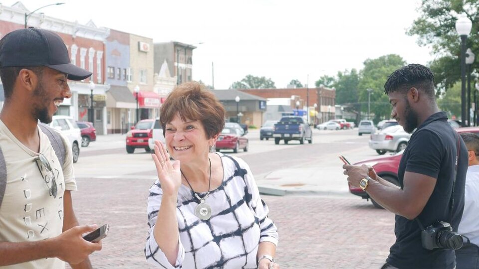 a woman and a man smiling and laughing as they walk downtown in the haymarket