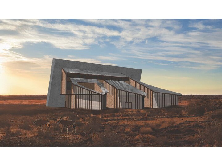 Modern angular building in a desert landscape under a cloudy sky at sunset.