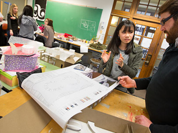 a student and faculty member looking at the layout of a building