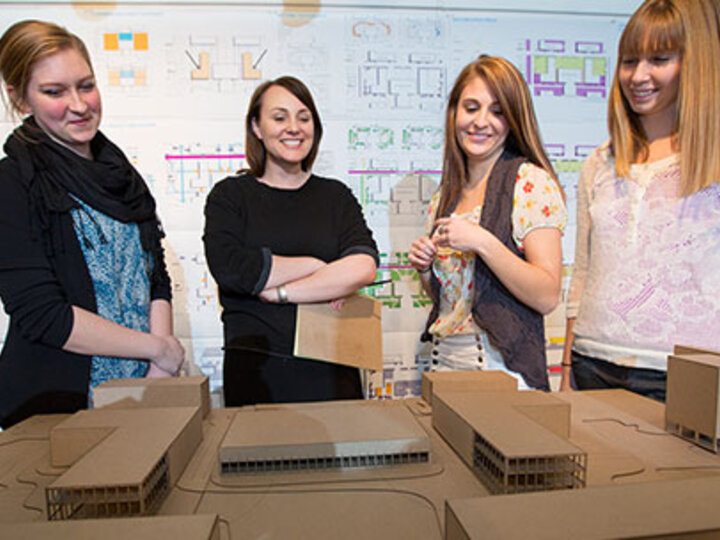 students smiling and looking at their project